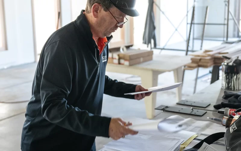 Construction Worker On Job Site Reviewing Plans